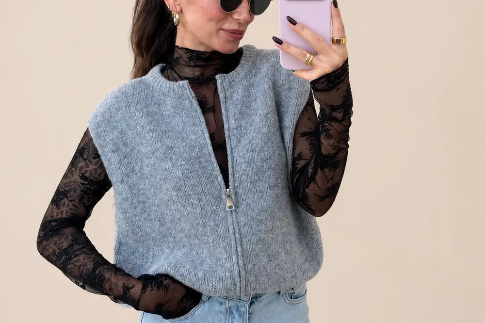 Donna in gilet in maglia grigio con zip su maglia nera in pizzo e jeans chiari | Lisa’s Boutique