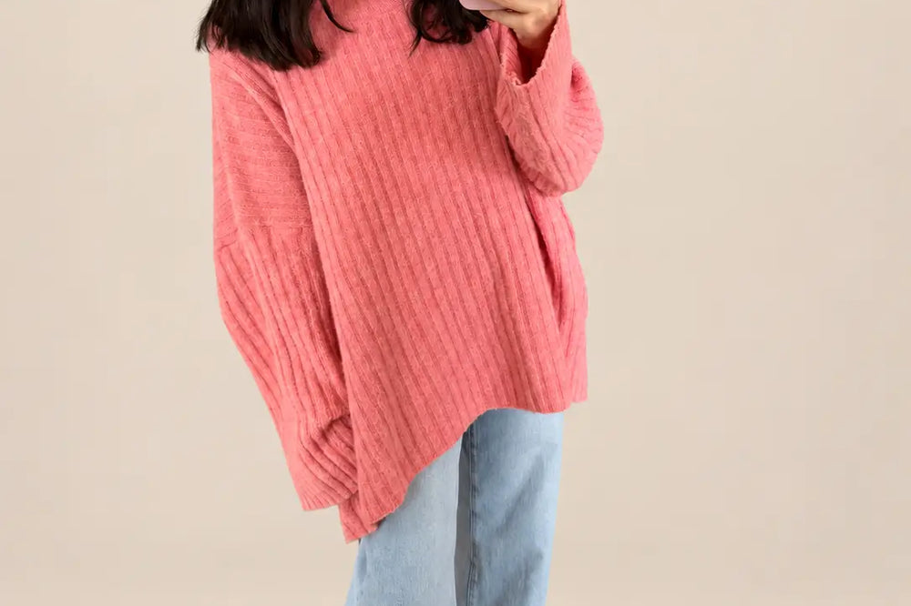 Apricot kombinieren: Gerippter Strickpullover in Apricot vor hellem Studiohintergrund | Lisa’s Boutique
