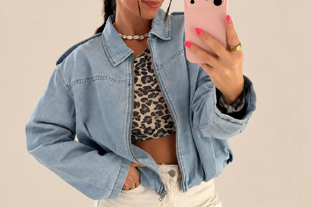 Jeansjacke kombinieren: kurze blaue Jeansjacke zu cremefarbener Hose vor hellem Hintergrund | Lisa’s Boutique