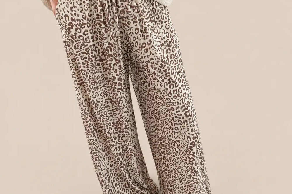 Reise Outfit Damen: weite Jersey Stoffhose mit Leoprint in Beige und Bindeband zu einem beigen Oberteil vor hellem Studiohintergrund | Lisa’s Boutique