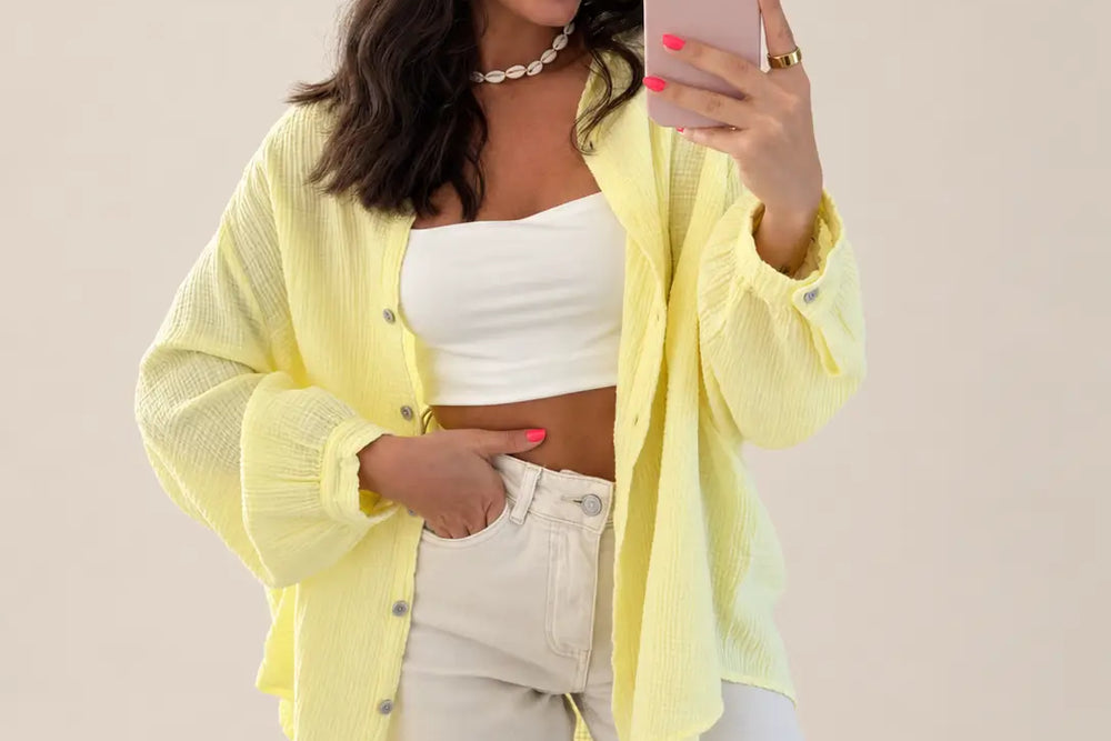 Frau in gelber Musselin Bluse offen über weißem Top zu heller Jeans | Lisa’s Boutique