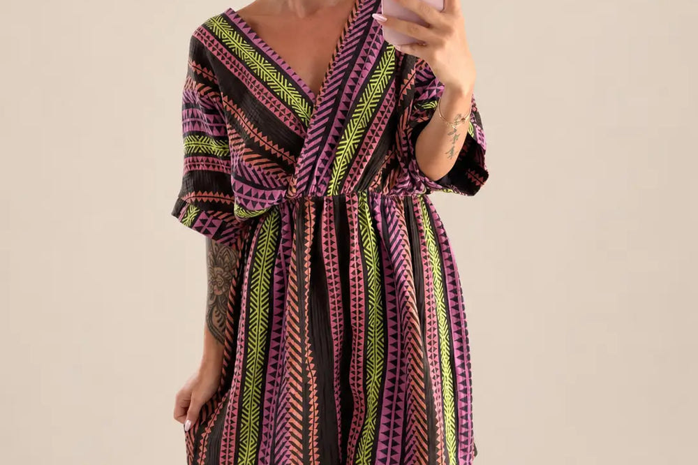Kobieta w krótkim muślinowym kombinezonie w kolorze brązowym/mix z dekoltem w szpic, elastycznym pasem i graficznym wzorem w zygzak | Lisa’s Boutique
