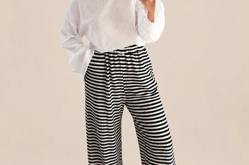 Gestreifte Strickhose Damen in Schwarz mit weitem Bein, dazu ein weißes Langarmshirt, Ganzkörperansicht am Model | Lisa’s Boutique