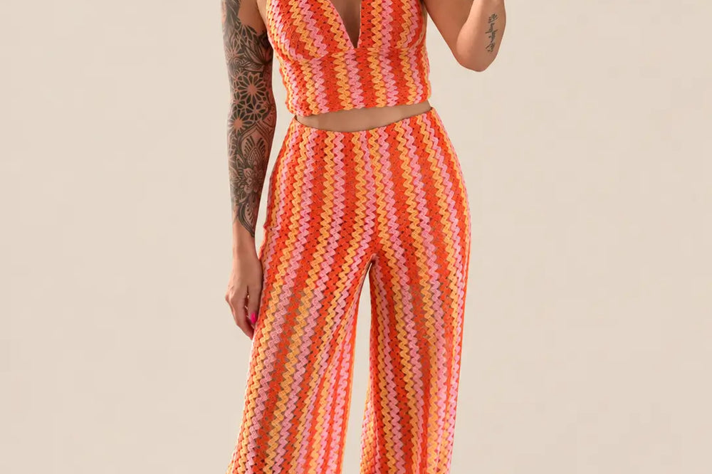 Welche Farbe passt zu Orange: orangefarbene Häkelhose mit Streifen und passendem Neckholder Top vor hellem Studiohintergrund | Lisa’s Boutique