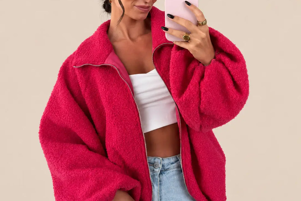 Welche Farbe passt zu Pink: pinke Bouclé Jacke mit weißem Top und heller Jeans vor hellem Studiohintergrund | Lisa’s Boutique