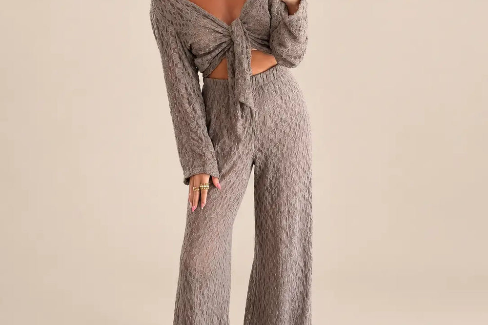 Frau in taupefarbenem Zweiteiler aus Spitze mit geknotetem Oberteil und weiter Hose als Brautmutter Outfit | Lisa’s Boutique