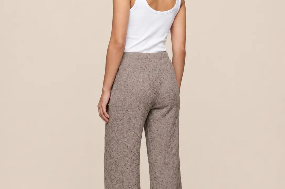 Elegantes Outfit Damen: Spitzenhose in Taupe mit weißem Top, Rückansicht vor hellem Studiohintergrund | Lisa’s Boutique