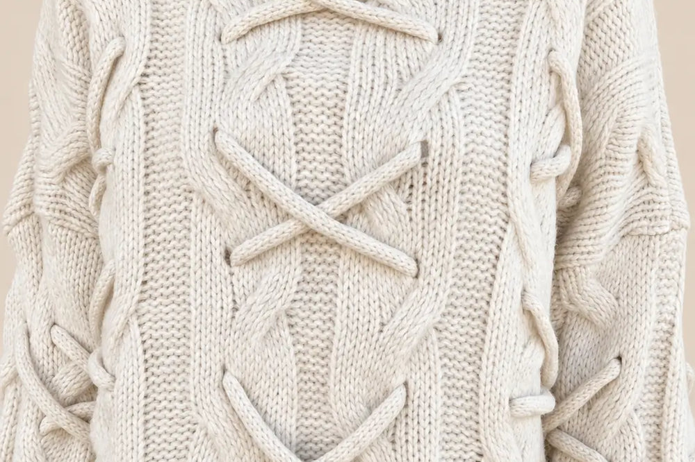 Preppy Style Damen: cremefarbener Strickpullover mit Zopfmuster und Schnürdetails in der Nahansicht | Lisa’s Boutique
