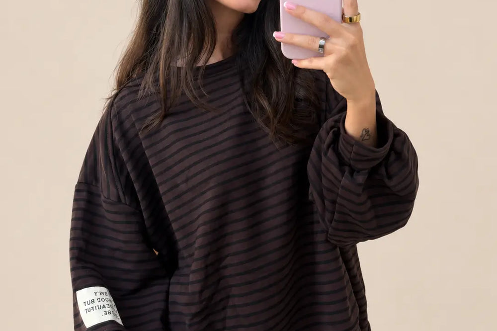 Satinrock kombinieren: gestreiftes Sweatshirt in Braun mit langen Ärmeln als mattes Oberteil vor hellem Hintergrund | Lisa’s Boutique
