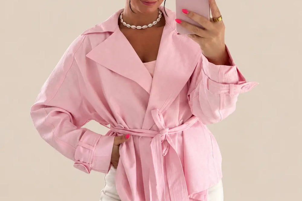 Frau in kurzem Trenchcoat in Rosa mit Bindegürtel zu heller Hose | Lisa’s Boutique
