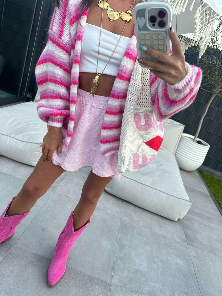 Zweiteiliges Strick-Set in Pink-Weiß mit gestreifter Strickjacke, passendem Minirock, weißem Crop-Top und pinken Cowboy-Stiefeln