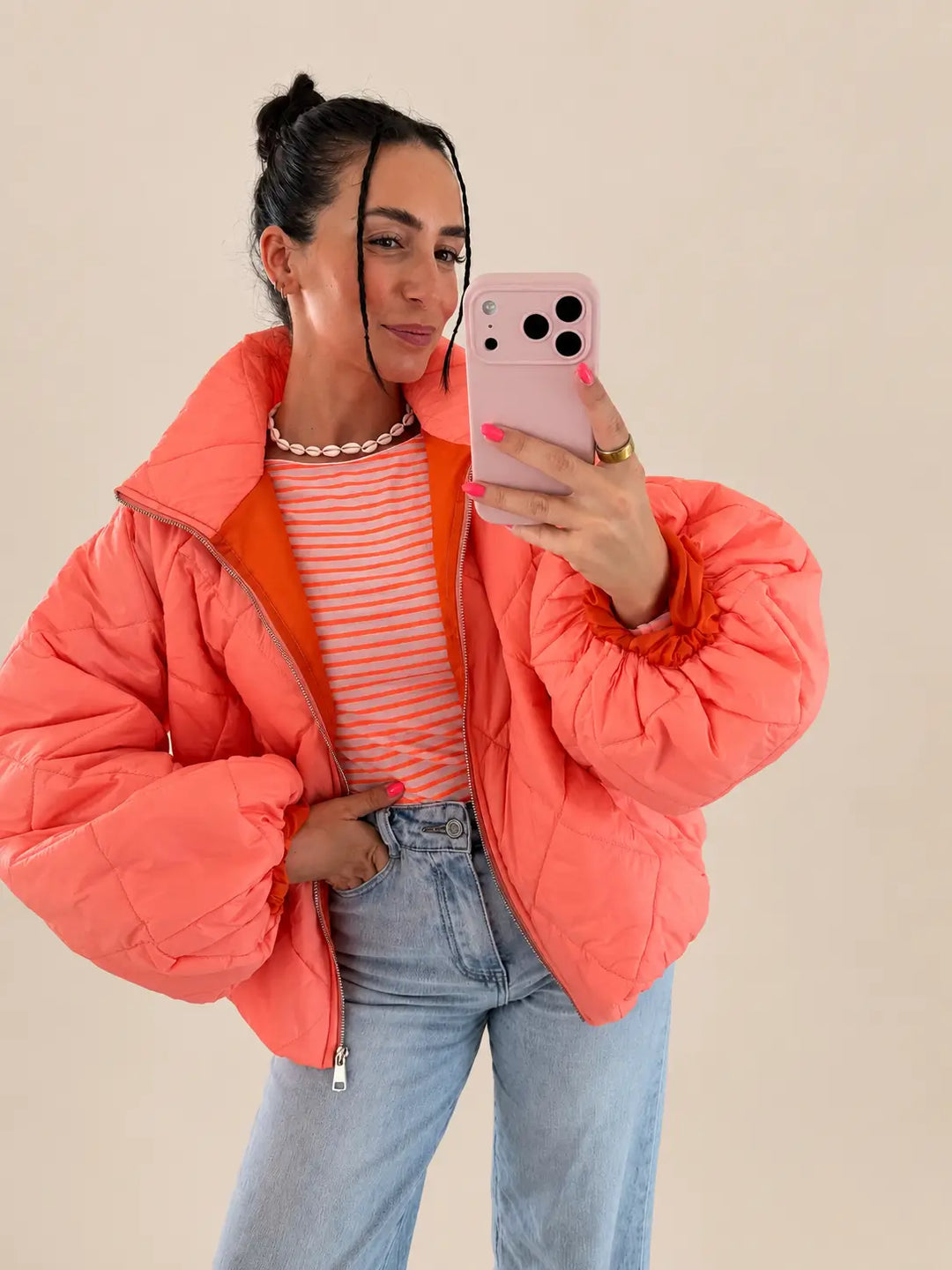 Maglia da donna a maniche lunghe a righe color albicocca sotto una giacca corallo aperta, foto in studio con jeans | Lisa’s Boutique