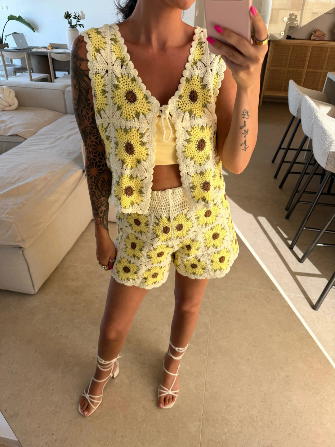 Gilet sans manches au crochet beige et jaune pour femme à motif fleuri, gros plan dans le salon avec short assorti | Lisa’s Boutique