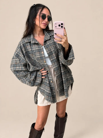 Camicia oversize donna in grigio con bottoni, aperta sopra un top bianco con gonna chiara, vista frontale | Lisa’s Boutique