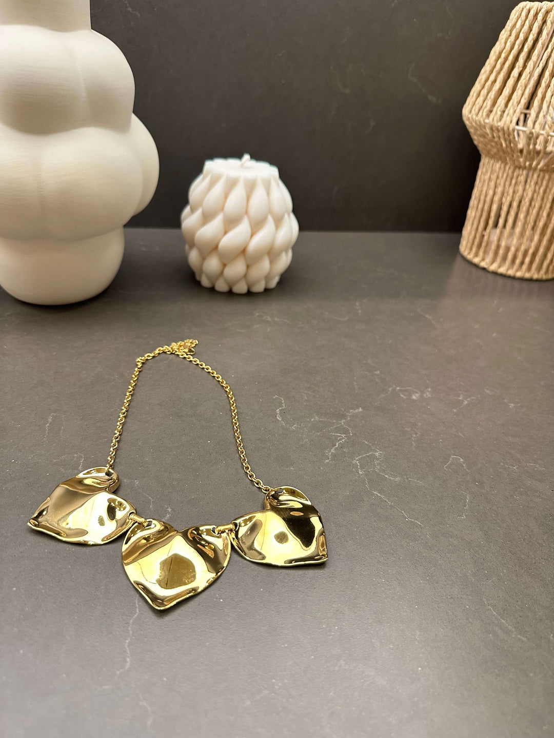 Goldene Statement-Kette mit drei asymmetrischen Gliedern auf dunklem Hintergrund