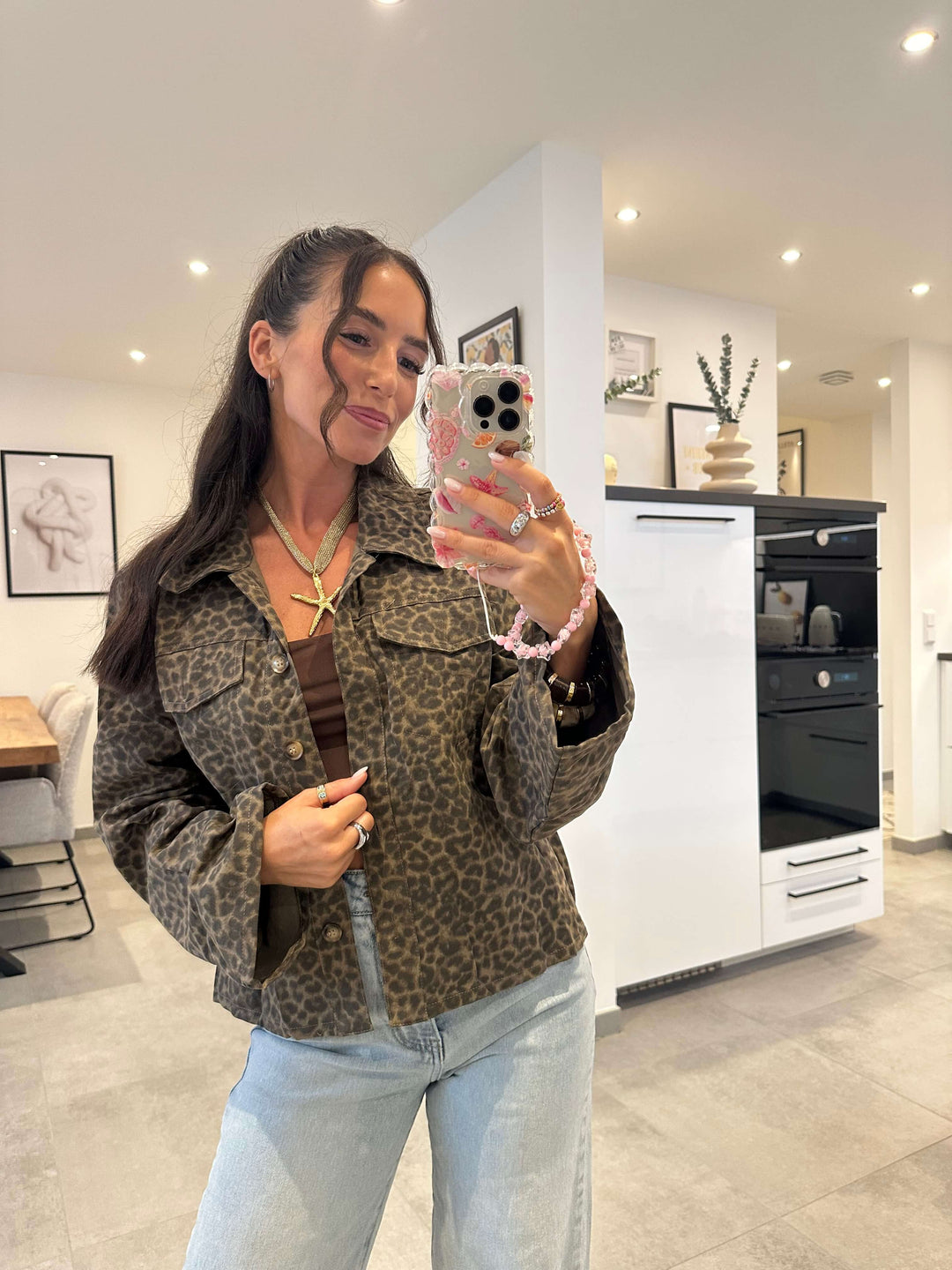 Beige-braune Jacke mit Leo-Muster, kastiger Schnitt, getragen über einem Bandeau-Top.