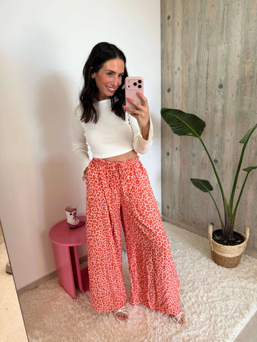 Losvallende broek met luipaardprint – Abrikoos – gedragen door een model | Lisa’s Boutique