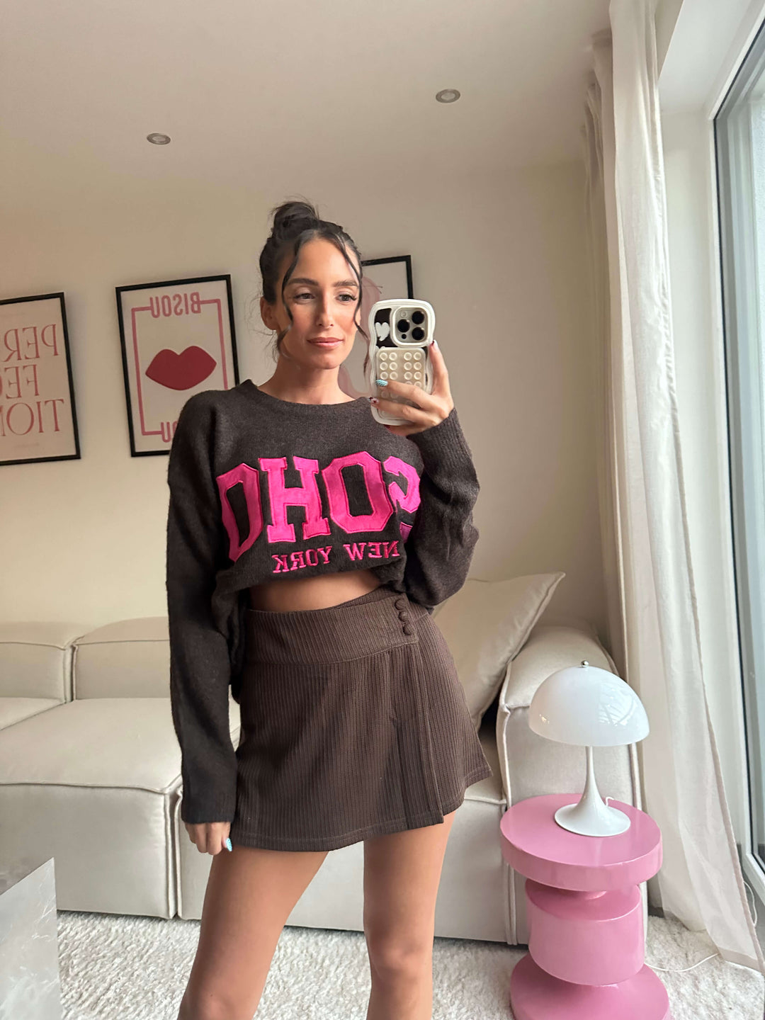 Lisa trägt einen dunkelbraunen Crop-Sweater mit pinkem „SOHO New York“-Schriftzug und einen passenden Minirock – Lisas-Boutique.