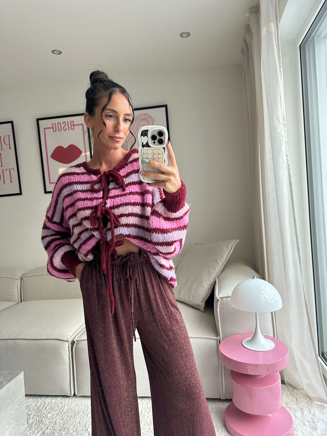 Lisa trägt einen pink-gestreiften Strickpullover mit Schnürung und eine weite Glitzerhose – Lisas-Boutique.