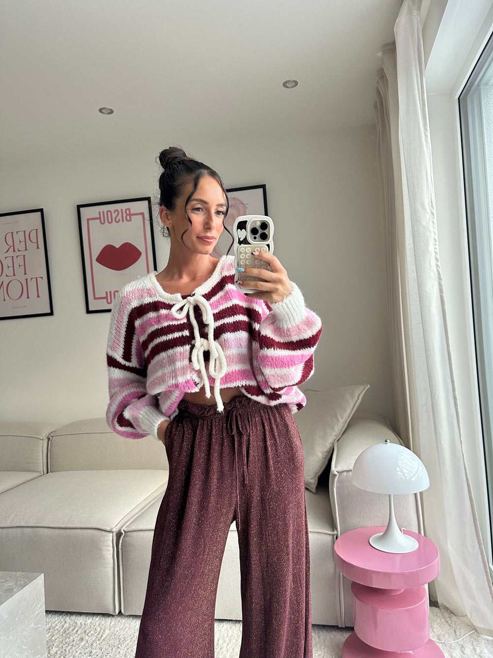 Lisa trägt einen pink-gestreiften Strickpullover mit weißer Schnürung und eine weite Glitzerhose – Lisas-Boutique.