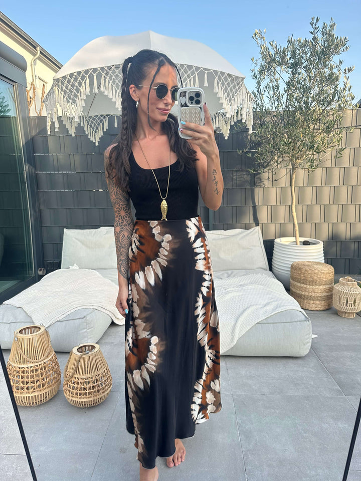 Maxirock in Schwarz mit Batikmuster, kombiniert mit schlichten Oberteilen, ideal für Sommer und Urlaub.