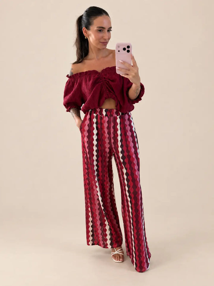 Women’s ruched muslin blouse in Bordeaux with patterned trousers, styled in an outfit | Lisa’s Boutique