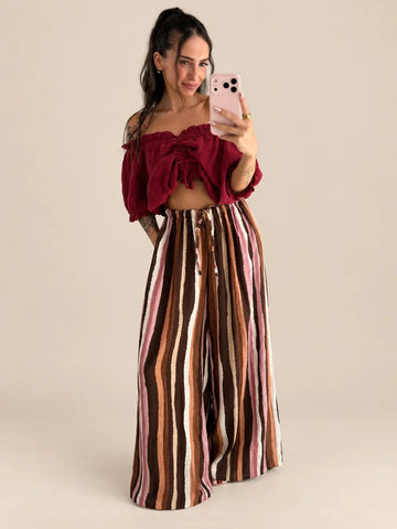 Blouse en gaze pour femme bordeaux avec fronces et volant, portée avec un pantalon rayé marron et crème | Lisa’s Boutique