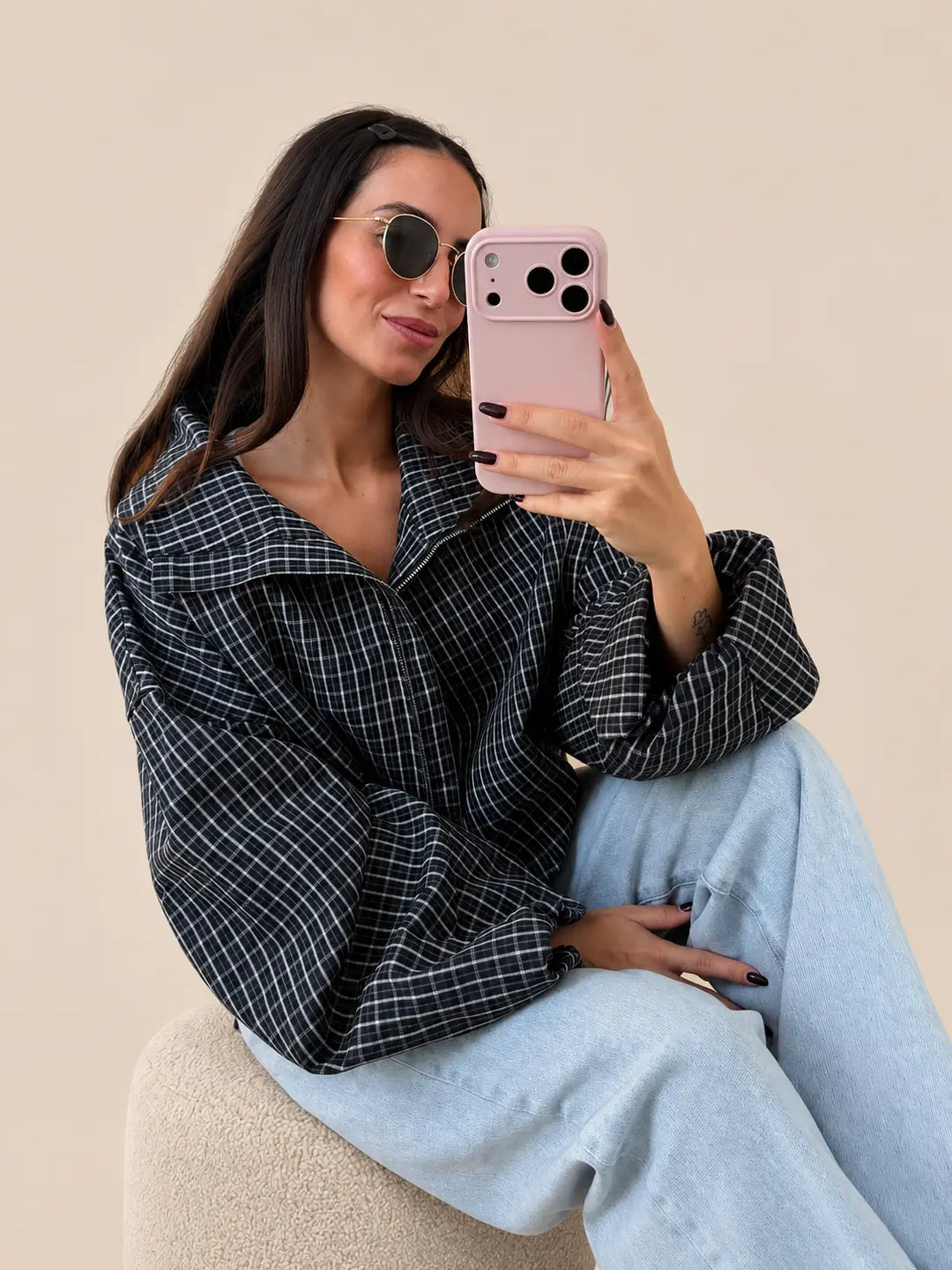Women’s navy blue oversized check jacket with a large collar, seated with light jeans | Lisa’s Boutique