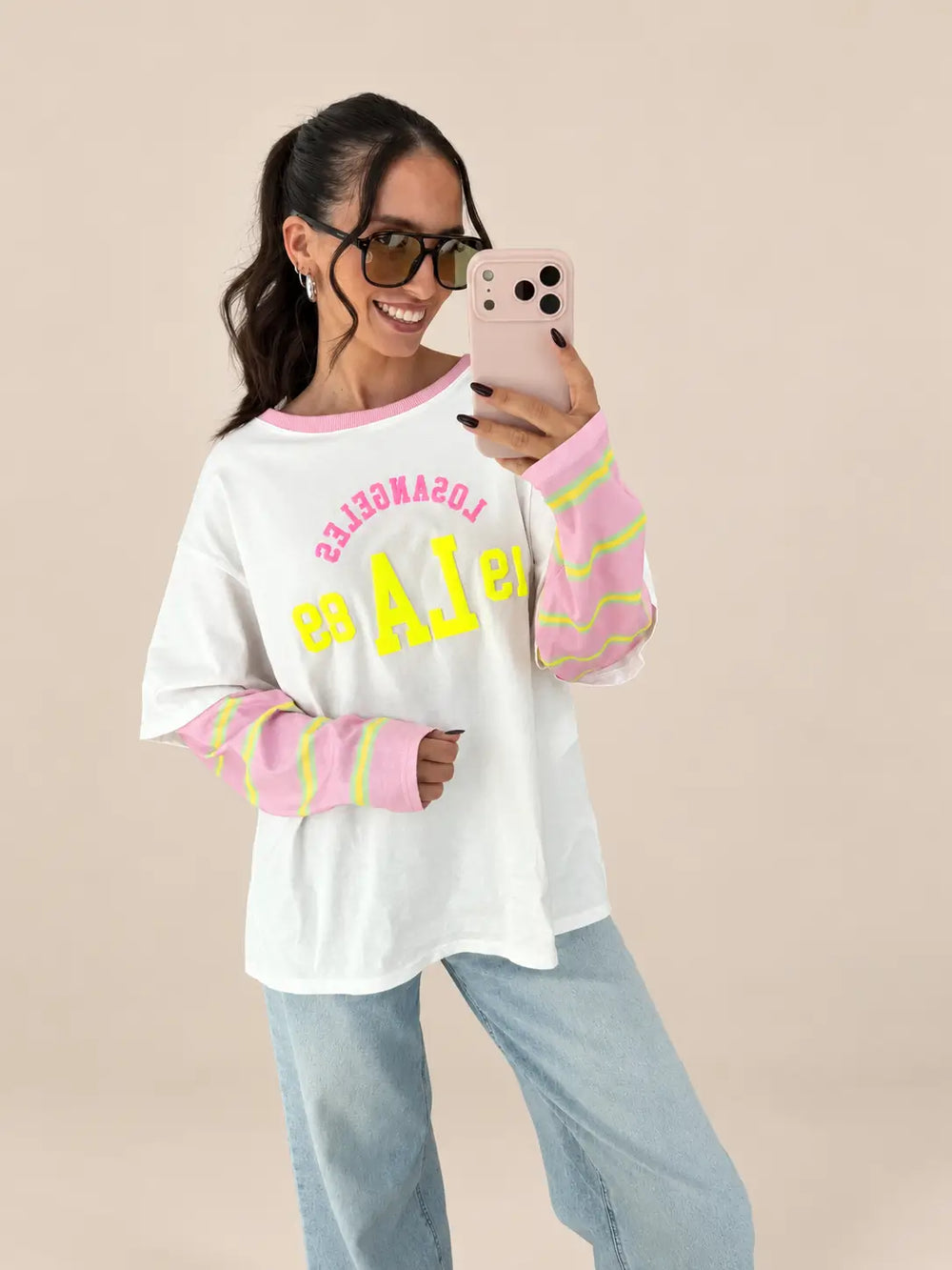 Oversize Shirt College Style in Rosa mit gelbem College-Print und rosa Ärmeldetails, kombiniert mit Jeans | Lisa’s Boutique