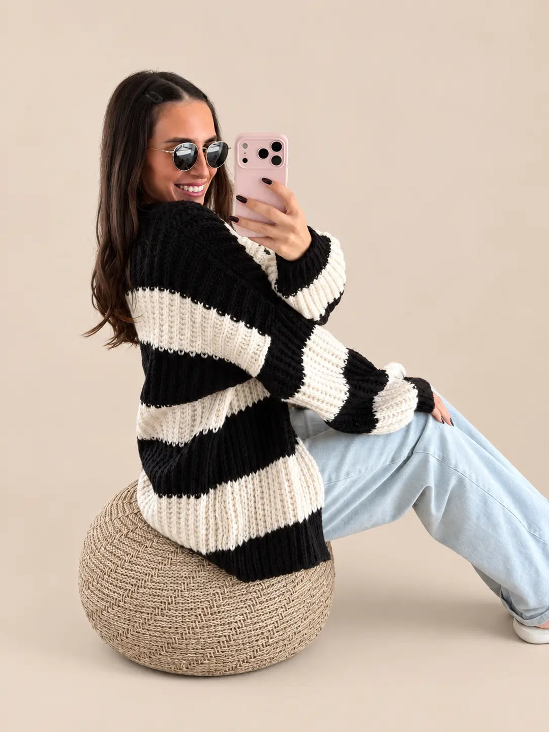 Vest dames in Zwart/Wit met brede strepen, zittend op een poef met jeans | Lisa’s Boutique
